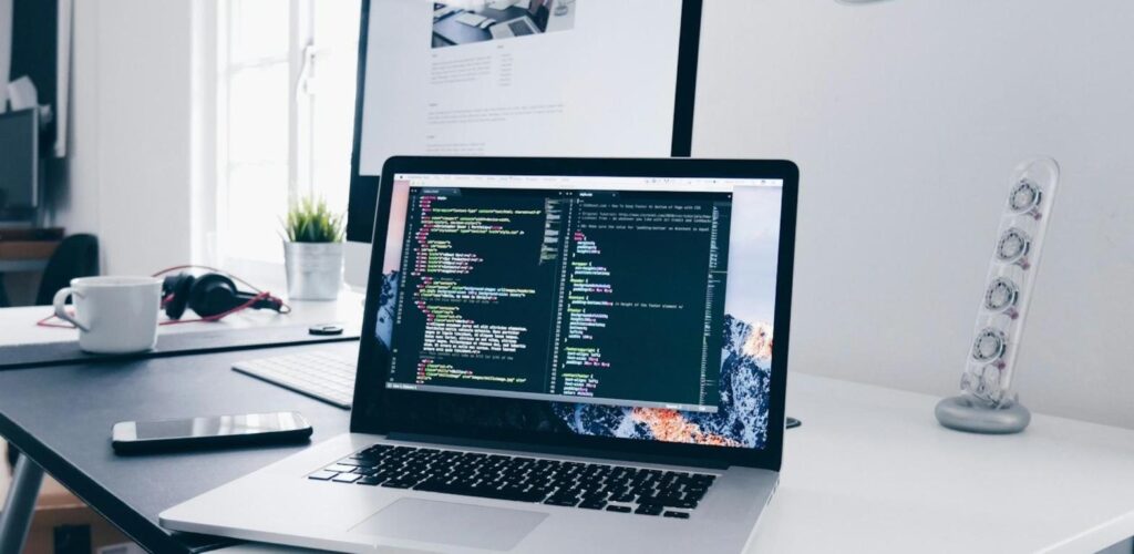 Laptop on a desk showing website code